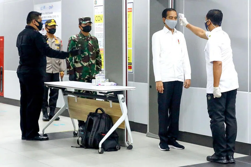 KEBIASAAN BARU: Presiden Indonesia, Encik Joko Widodo (dua dari kanan) memakai pelitup dan menjalani pemeriksaan suhu badan semasa mengunjungi sebuah stesen MRT di Jakarta semalam, bagi memeriksa langkah-langkah yang dilaksanakan bagi mengekang penularan koronavirus. 