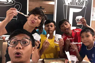 IBARAT SATU KELUARGA: Cik Bernice Wong (kiri, berbaju hitam) sering mengorbankan masa, tenaga dan wang ringgit demi membantu meningkatkan mutu kehidupan para belia yang tinggal di rumah-rumah sewa di Yishun. Antara belia itu termasuk Muhd Arash Shahul Hameed (tengah, berbaju kuning) dan Muhammad Hafizhan Salim (kanan, berbaju merah). - Foto ihsan BERNICE WONG