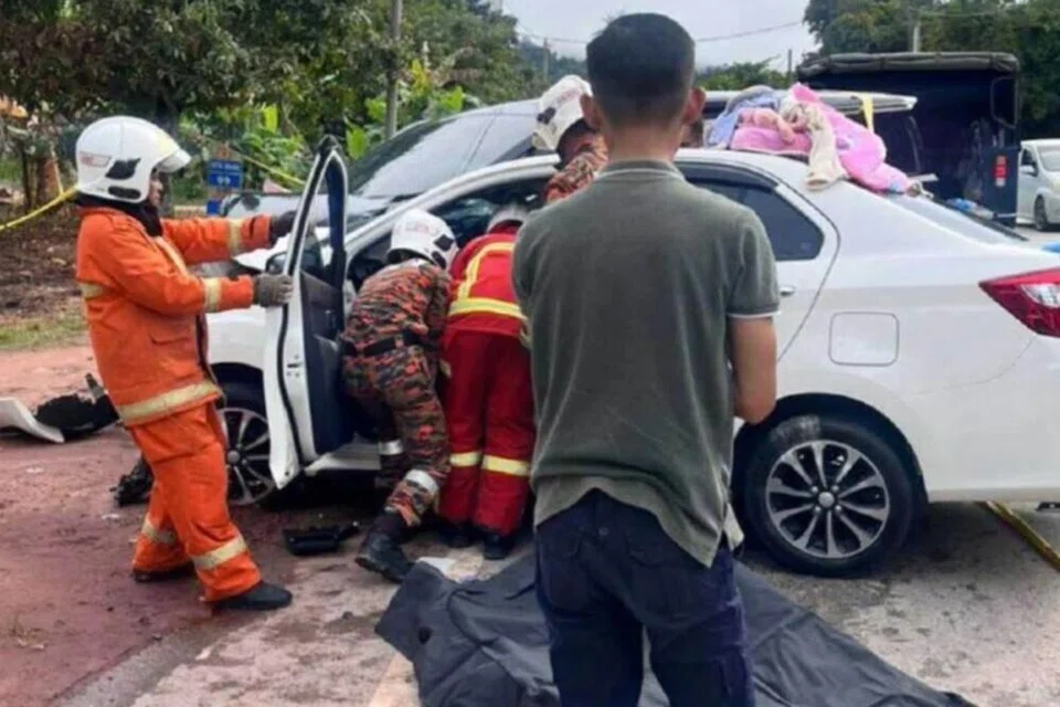 Anggota bomba mengeluarkan empat beranak yang terbabit dalam kemalangan di Jalan Gua Musang-Kuala Krai, Kelantan, pada pagi Aidiladha, 27 Mei.