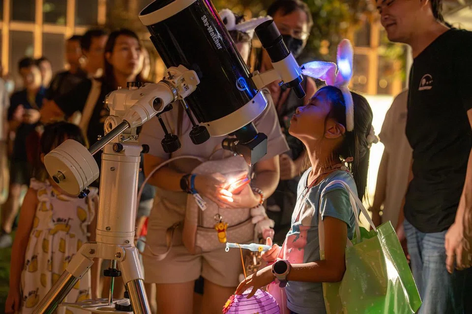 Pengunjung boleh melihat bulan dengan menggunakan teleskop yang disediakan oleh Pusat Sains Singapura semasa festival, ‘Mid Autumn Family Fun’.