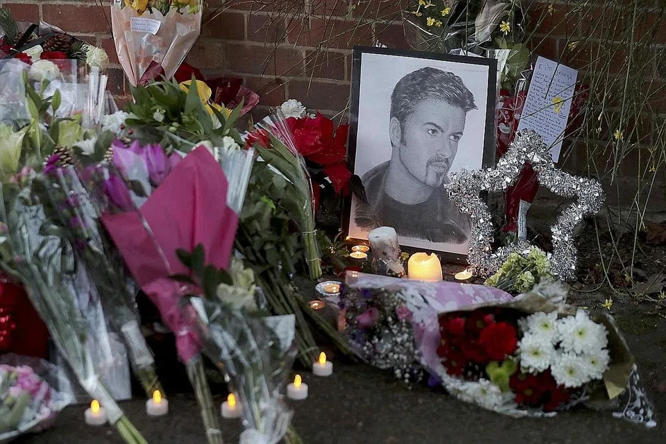 DIRUNDUNG DUKA: Jambangan bunga dan lilin diletakkan di luar rumah mendiang Michael, England selatan, di mana beliau meninggal dunia. - Foto REUTERS