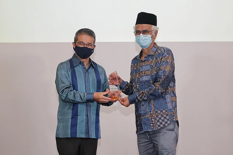 DIIKTIRAF: Menteri Kebudayaan, Masyarakat dan Belia, Encik Edwin Tong (kiri), menyampaikan Anugerah Tun Seri Lanang - anugerah paling berprestij persuratan Melayu Singapura - kepada penerimanya tahun ini, Encik Hamed Ismail, dalam Majlis Anugerah Persuratan ke-14 yang diadakan di Muzium Tamadun Asia semalam. - Foto BM oleh GIN TAY