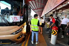 ANTARA YANG PERTAMA: Antara penumpang pertama yang menaiki bas untuk ke seberang Tambak pada hari pertama VTL (Darat) antara Singapura dengan Malaysia bermula dari Pusat Pertukaran Bas Sementara Woodlands menuju ke Terminal Bas Larkin Sentral di Johor Bahru semalam. - Foto-foto BH oleh LIM YAOHUI 