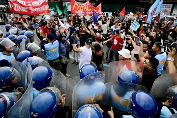 Anggota polis antirusuhan menghalang kumpulan penunjuk perasaan yang berhimpun di jalan menuju ke bangunan Kongres Filipina di Quezon City, Metro Manila, pada 27 Julai 2026. Demonstrasi diadakan serentak dengan Ucapan Negara (SONA) Presiden Ferdinand Marcos Jr, dengan peserta menggesa pembaharuan dalam aspek hak asasi manusia, tadbir urus dan politik negara.