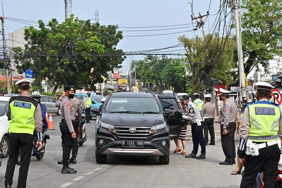 Pegawai polis Indonesia memeriksa penumpang dalam kenderaan mereka di sempadan antara Jakarta dengan Tangerang setelah pemerintah mengenakan sekatan sosial besar-besaran untuk mengekang penyebaran Covid-19 di Jakarta pada 27 April lalu.