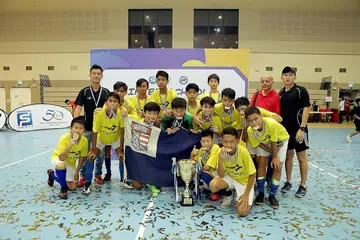 PENCAPAIAN LUAR DUGAAN: Para pemain Sekolah Menengah Bartley dan pegawai pasukan meraikan kejayaan muncul juara Piala Cabaran Futsal Bawah 14 Tahun FAS-Singapore Pools yang diadakan di Our Tampines Hub. - Foto FAS