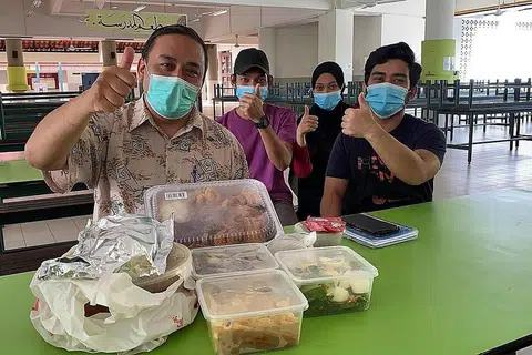 IFTAR AMAL: Ustaz Mohd Zakir Isahak bersama beberapa tukang masak belia dari Malaysia yang bekerja di kantin madrasah itu bersama sajian makanan iftar yang mereka sediakan. - Foto MADRASAH ALJUNIED AL-ISLAMIAH
