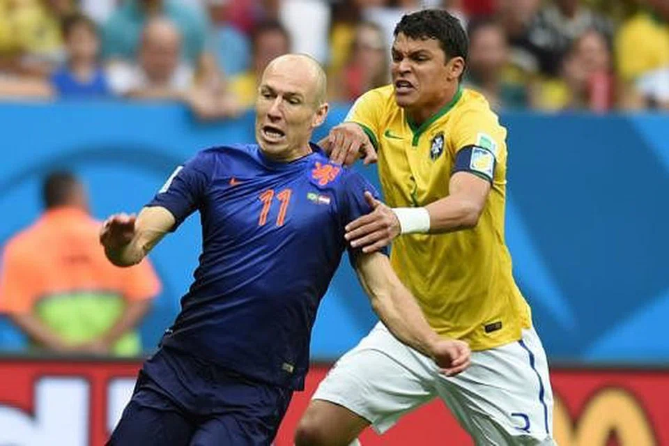 1-0: Kapten Brazil, Thiago Silva (jersi kuning), cuba menarik Arjen Robben menyebabkan pengadil memberikan sepakan penalti kepada Belanda yang disempurnakan Robin van Persie. - Foto AFP