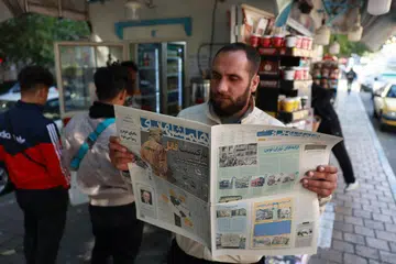Seorang lelaki Iran membaca akhbar harian, ‘Hamshahri’, dengan gambar Encik Donald Trump berpakaian seperti banduan dan tertera tajuk besar, ‘Kepulangan Pembunuh’, semasa di luar sebuah kios di Teheran, Iran, pada 7 November. 