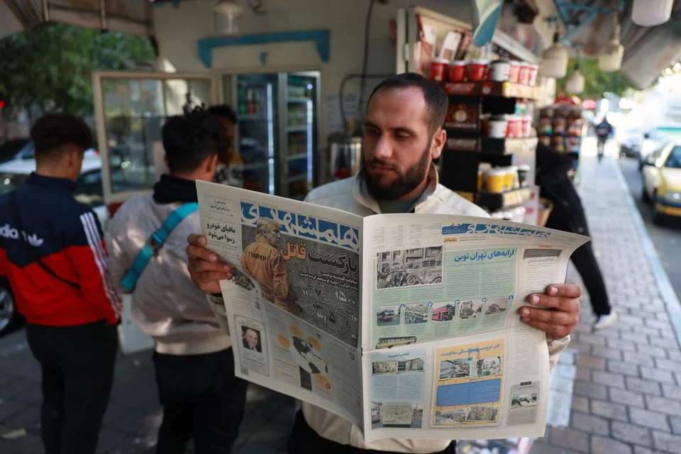 Seorang lelaki Iran membaca akhbar harian, ‘Hamshahri’, dengan gambar Encik Donald Trump berpakaian seperti banduan dan tertera tajuk besar, ‘Kepulangan Pembunuh’, semasa di luar sebuah kios di Teheran, Iran, pada 7 November. 