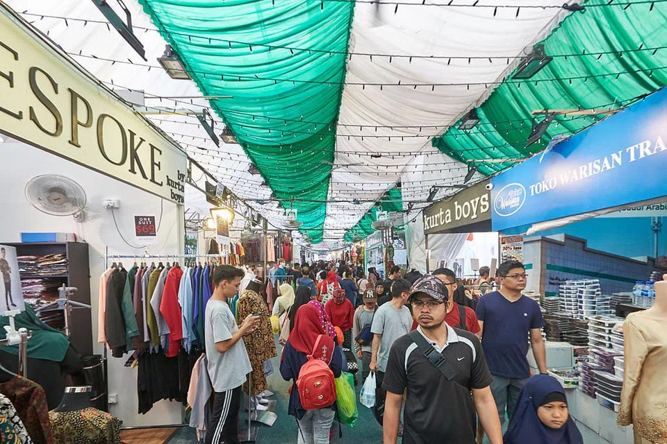 IMBAS KEMBALI: Hiasan lampu di Geylang Serai dan bazar Hari Raya tahun lalu. - Foto fail