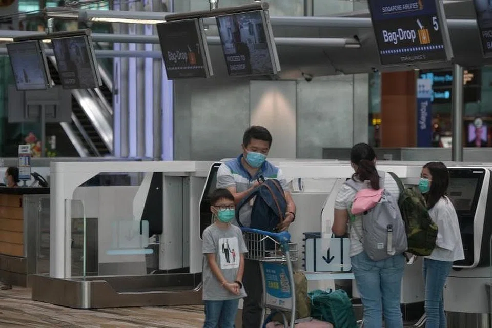 Sebuah keluarga memakai pelitup di kawasan 'check-in' SIA di Terminal 3 Changi Airport pada 14 Februari lalu. 