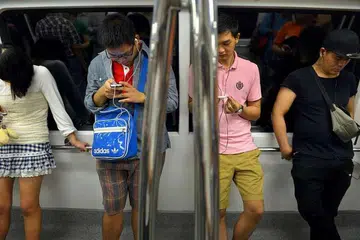 Penumpang menggunakan telefon bimbit di dalam kereta api MRT. Sesebuah rangkaian dianggap telah "meliputi" sesebuah kawasan jika telefon menunjukkan kekuatan isyarat sekurang-kurangnya satu ketak - cukup untuk membuat panggilan telefon dan menghantar mesej teks - di kawasan itu.