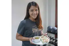 SIAPKAN MAKANAN LEBIH AWAL: Cik Aqilah menasihatkan pekerja yang bertugas mengikut giliran supaya membawa bekal makanan yang disiapkan sendiri supaya tidak terdesak membeli makanan yang mungkin kurang sihat yang dijual di tempat kerja. Kelihatan Cik Aqilah memegag sepiring gulungan Popia Udang Vietnam Segar Dengan Sos Kacang yang resipinya di kanan. - Foto BH oleh IQBAL FAIZAL