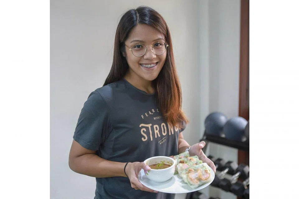 SIAPKAN MAKANAN LEBIH AWAL: Cik Aqilah menasihatkan pekerja yang bertugas mengikut giliran supaya membawa bekal makanan yang disiapkan sendiri supaya tidak terdesak membeli makanan yang mungkin kurang sihat yang dijual di tempat kerja. Kelihatan Cik Aqilah memegag sepiring gulungan Popia Udang Vietnam Segar Dengan Sos Kacang yang resipinya di kanan. - Foto BH oleh IQBAL FAIZAL