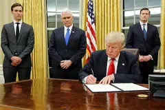 SEGERA BERTUGAS: Encik Donald Trump (duduk) menandatangi arahan eksekutifnya yang pertama di Pejabat Oval semalam dengan diperhatikan (dari kiri) Penasihat Kanan, Encik Jared Kushner; Naib Presiden Mike Pence; dan Setiausaha Kakitangan, Encik Rob Porter. - Foto REUTERS