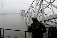 Seorang pekerja Lembaga Keselamatan Pengangkutan Kebangsaan (NTSB) melihat kapal kargo Dali, yang melanggar sehingga menyebabkan Jambatan Francis Scott Key, di Baltimore, Maryland, runtuh.