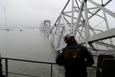 Seorang pekerja Lembaga Keselamatan Pengangkutan Kebangsaan (NTSB) melihat kapal kargo Dali, yang melanggar sehingga menyebabkan Jambatan Francis Scott Key, di Baltimore, Maryland, runtuh.