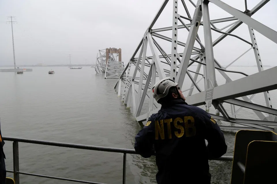 Seorang pekerja Lembaga Keselamatan Pengangkutan Kebangsaan (NTSB) melihat kapal kargo Dali, yang melanggar sehingga menyebabkan Jambatan Francis Scott Key, di Baltimore, Maryland, runtuh.
