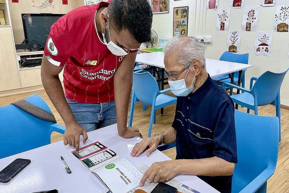 BIMBING WARGA EMAS: Siswa NTU Rishiikanthan Vijayahkumar, 25 tahun, membantu Encik Kassim Jumali, 82 tahun, menggunakan aplikasi WhatsApp dalam bengkel anjuran kempen celik IT '#CanOneLah!' baru-baru ini. Selain menjadi cara berhubung, Encik Kassim menggunakan aplikasi WhatsApp dan WhatsApp Call untuk menunjukkan berita menarik laporan akhbar ini kepada anaknya yang menetap di Malaysia. - Foto #CANONELAH! 