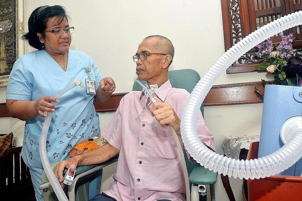 SOKONGAN JURURAWAT: Encik Sahari Musa mendapat sokongan jururawat amali lanjutan atau 'advanced practice nurse' (APN) Hospital Tan Tock Seng, Cik Kamilah Sheikh Jabin, yang datang ke rumah beliau untuk memantau keadaan kesihatannya, selain memastikan mesin penyokong pernafasan beliau dalam keadaan baik. - Foto KHALID BABA