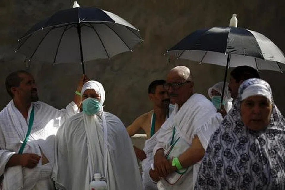 MENUNGGU: Jemaah menanti kedatangan bas semalam. - Foto REUTERS