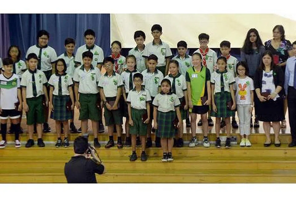 CEKAL HATI: Murid TKPS yang terselamat dan keluarga mangsa gempa yang melanda Gunung Kinabalu Jun lalu bergambar bersama Profesor Madya Faishal Ibrahim (depan, kanan sekali) selepas penyampaian pingat semalam. - Foto TAUFIK A. KADER