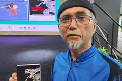 Penulis Abdul Manaf Abdul Kadir, bergambar dengan buku, ‘Kembar Pendekar’ (bahagian pertama), yang dilancarkan semasa Pesta Buku Melayu Singapura 2024 pada Ogos. 