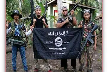(Dari kiri) Seorang pejuang Abu Sayyaf dan militan Malaysia, Mahmud Ahmad, Muhammad Joraimee Awang Raimee dan Muammar Gaddafi, bergambar dengan bendera ISIS. Militan Malaysia yang bersembunyi di selatan Filipina dipercayai merancang membentuk puak "rasmi" ISIS di Asia Tenggara dengan mengumpulkan kumpulan pengganas di Malaysia, Indonesia dan Filipina, termasuk Jemaah Islamiah dan Abu Sayyaf. 