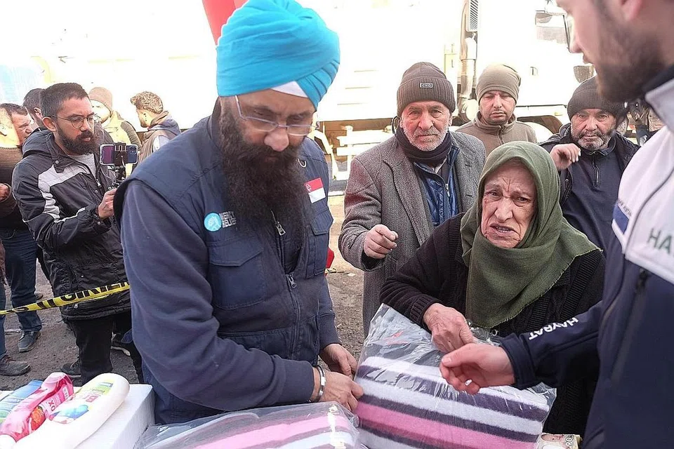 BANTU MANGSA: Pengurus Mercy Relief, Encik Satwan Singh, mengedarkan selimut kepada penduduk di bandar Elbistan, Turkey, dalam usaha membantu mereka menghadapi cuaca sejuk. - Foto BH oleh IZWANDI AZMAN