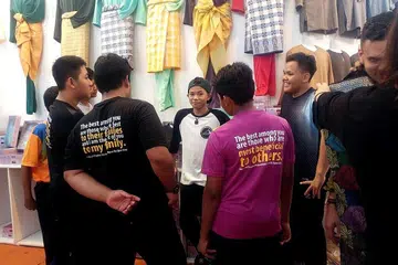 LAHIR SIMPATI DAN BERI MOTIVASI: Tegar Septian (tengah) memberi kata-kata perangsang kepada penghuni Rumah Kebajikan Muhammadiyah (RKM) yang dibawa ke gerai Jakel Singapore di Tanjong Katong Complex bagi mencuba baju Melayu. - Foto CHAPALANG TEAM