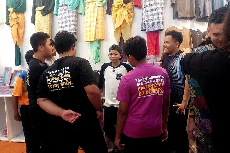 LAHIR SIMPATI DAN BERI MOTIVASI: Tegar Septian (tengah) memberi kata-kata perangsang kepada penghuni Rumah Kebajikan Muhammadiyah (RKM) yang dibawa ke gerai Jakel Singapore di Tanjong Katong Complex bagi mencuba baju Melayu. - Foto CHAPALANG TEAM
