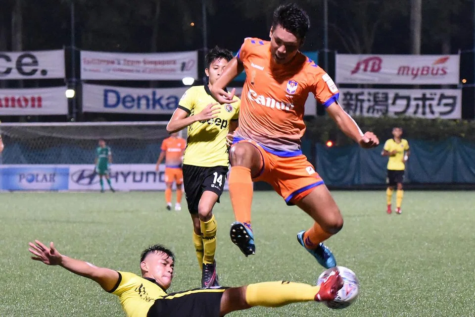 MEMPERTAHANKAN GAWANG: Fadli Khamis berjaya membendung kelincahan Kenya Takahashi (jersi jingga) dalam perlawanan yang berlangsung di stadium Jurong East kelmarin. - Foto ZAINAL YAHYA