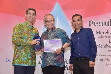TERIMA HADIAH: Encik Adam Fadila (tengah) meraih wang tunai $5,000 dan piala yang disampaikan oleh Dr Muhammad Faishal Ibrahim. Kanan ialah Editor Berita Harian/Minggu, Encik Saat A. Rahman. - Foto BH oleh IQBAL FAIZAL