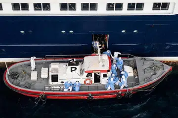 Pandangan dari udara menunjukkan kakitangan kesihatan membantu pesakit menaiki bot dari kapal persiaran, ‘MV Hondius’, ketika berada di luar pelabuhan Praia, ibu kota Cape Verde, pada 6 Mei 2026. Jangkitan penyakit bawaan tikus, hantavirus, di atas kapal itu telah menyebabkan tiga kematian sejauh ini.