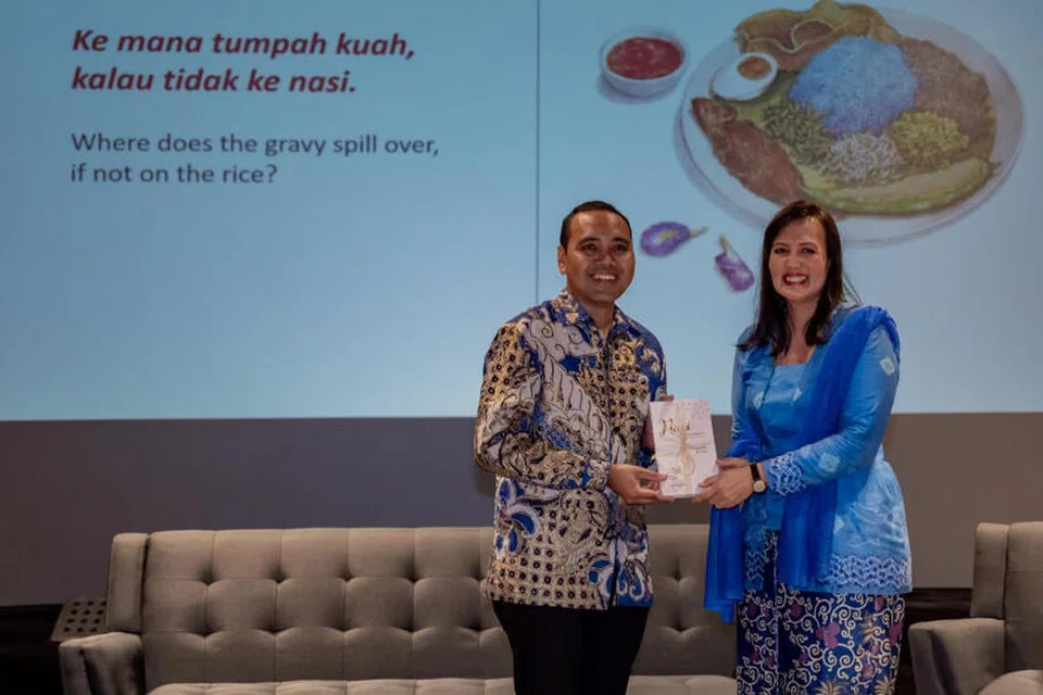 PELANCARAN BUKU: Penulis, Cik Hidayah Amin, memberi senaskhah buku ‘Nasi: When Rice Grains Cry; A Pictorial Guide to Malay Rice Dishes’ kepada Encik Zhulkarnain Abdul Rahim semasa majlis pelancaran buku tersebut di Wisma Geylang Serai pada Ahad.