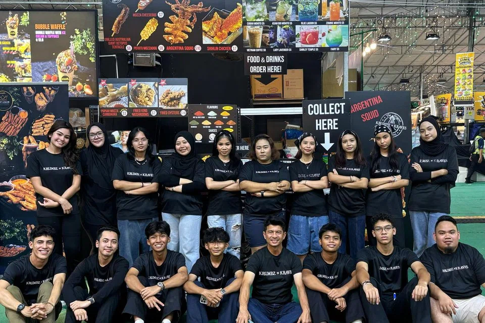 (Berdiri, dua dari kiri) Cik Ellyana Roslani, pemilik Krumbz N Kraves, sering menyewa gerai di acara ekspo musiman sejak 2013. Kini, beliau mempunyai 32 kakitangan untuk mengendalikan gerainya. 