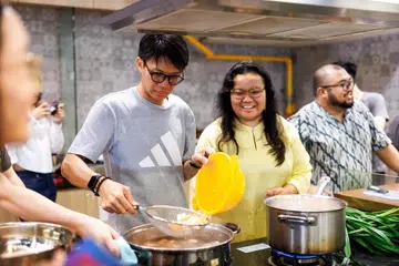 Seorang peserta bersama pengasas bersama Sendok Rakyat, Cik Anugerah Murni (tengah) dan Encik Aqid Aiman (kanan), semasa program Kelab Masakan Geylang Serai.