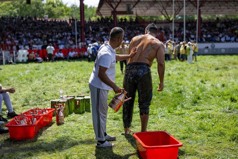 Tubuh penggusti disapu dengan minyak zaitun sebagai persiapan sebelum pertarungan. 