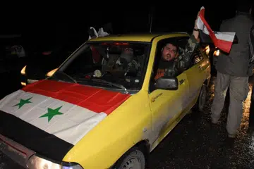 KEGEMBIRAAN WARGA: Kejayaan tentera Syria merampas kembali bandar Aleppo diraikan para penduduk negara itu. - Foto AFP