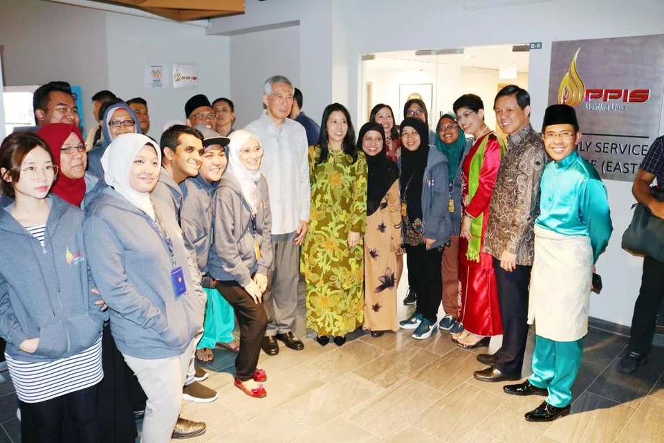 Mantan Perdana Menteri, Encik Lee Hsien Loong (tengah, berbaju putih), melawat Pusat Khidmat Keluarga PPIS di Wisma Geylang Serai pada 2019.