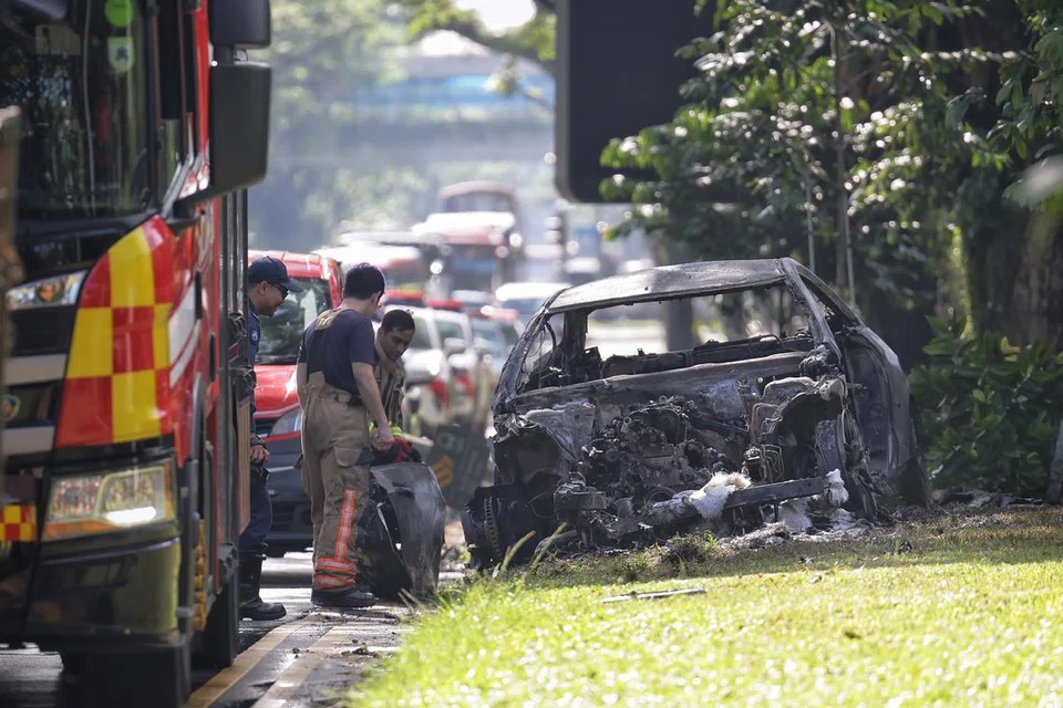 Pegawai SCDF kelihatan memeriksa bangkai kereta yang terbakar selepas kemalangan berlaku di Bukit Timah Road pada 6 Mac.