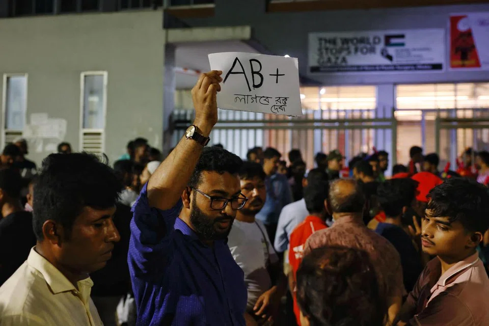 Seorang penderma darah sukarela memegang plakad yang menyatakan kesediaannya untuk menderma darah jenis AB(+) kepada mangsa, jika diperlukan, di hadapan sebuah hospital selepas sebuah pesawat latihan Tentera Udara terhempas ke sebuah bangunan milik Milestone School and College di Dhaka, Bangladesh, pada 21 Julai 2025. 