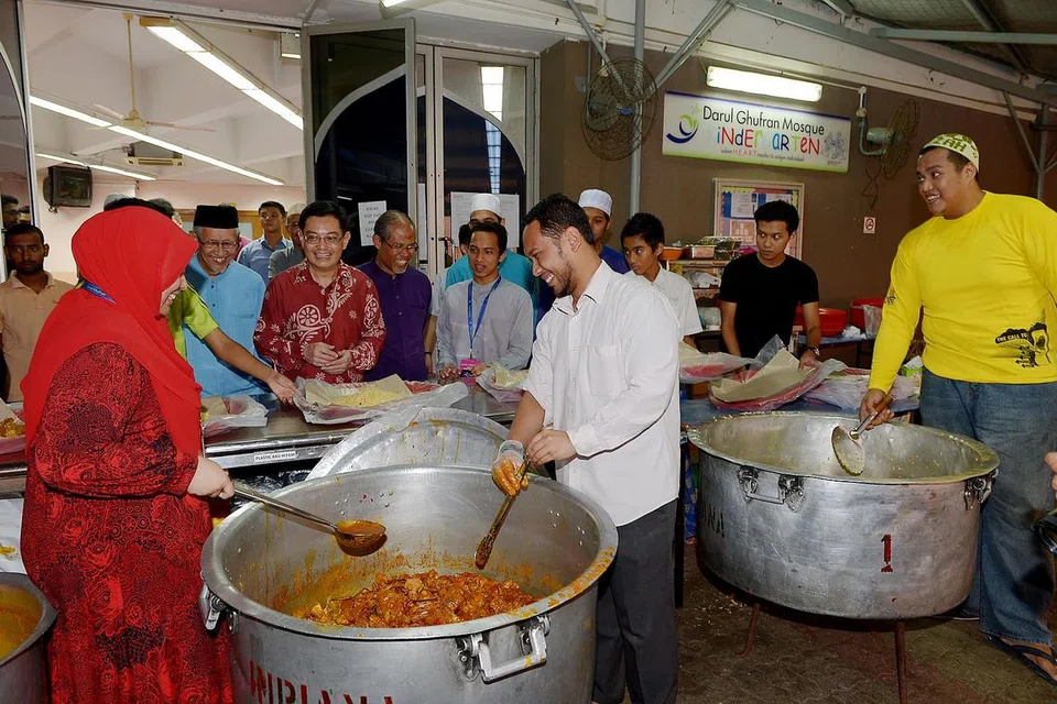 MELAWAT MASJID: Encik Heng melawat Masjid Darul Ghufran semasa sukarelawan masjid menyiapkan makanan untuk berbuka puasa pada Julai 2015. - Foto-foto fail