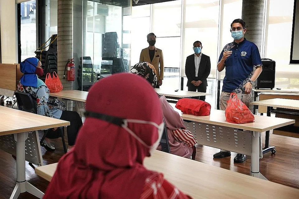 RAIH KEMAHIRAN: Profesor Madya Dr Muhammad Faishal Ibrahim (kanan) berinteraksi bersama peserta yang mengikuti kursus merancang kewangan anjuran Mesra di Kelab Masyarakat Taman Jurong semalam. - Foto BH oleh KHALID BABA