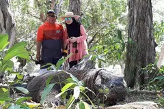 HASRAT TERCAPAI: Walaupun rasa takut, penulis dan suami beranikan diri berfoto bersama naga komodo yang sedang berehat. - Foto ihsan HASNAH ABDULLAH