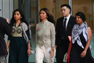 Siti Amirah Mohamed Asrori (kiri), dan Annamalai Kokila Parvathi (kanan) kelihatan di luar mahkamah bersama peguam bela Encik Derek Wong pada 25 Julai.