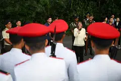 HARGAI KHIDMAT: Puan Halimah menyampaikan ucapan sewaktu menyaksikan istiadat pertukaran pengawal yang berlangsung di Istana pada Ahad. Upacara itu disaksikan ramai pejalan kaki (gambar atas).