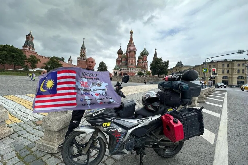 JELAJAH DUNIA: Pengarah bengkel motosikal dan juara perlumbaan motosikal Malaysia Encik Kenny Lee kelihatan bergambar dekat Kremlin di Moscow, Russia dengan motosikal ‘kapcai’ beliau yang berkuasa 155 cc.