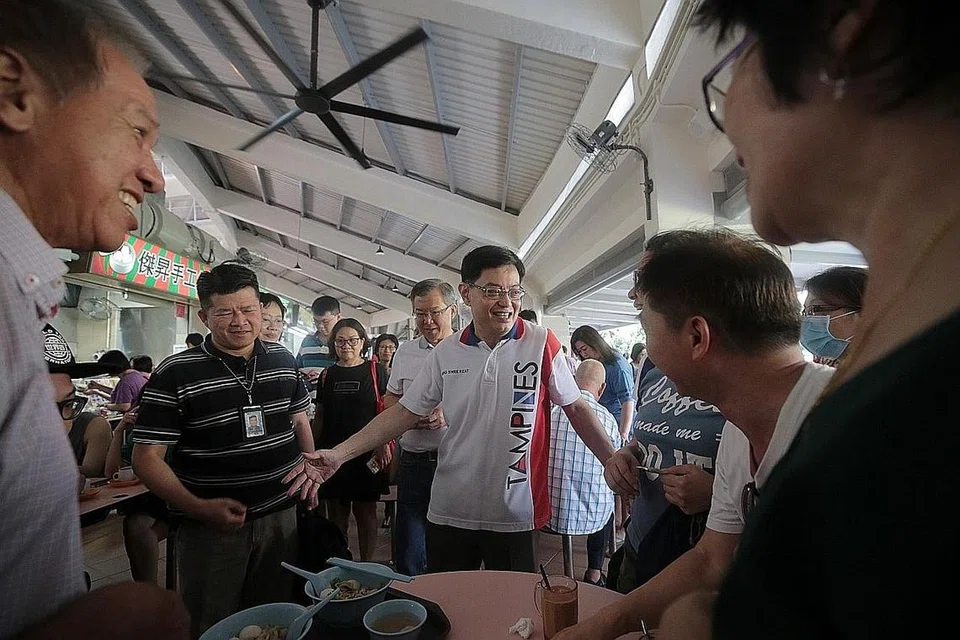PERTINGKAT KEMUDAHAN: Encik Heng sedang berinteraksi dengan penduduk Tampines selepas Pasar Bulat dan Pusat Makanan Tampines dibuka semula semalam. - Foto BH oleh JASON QUAH